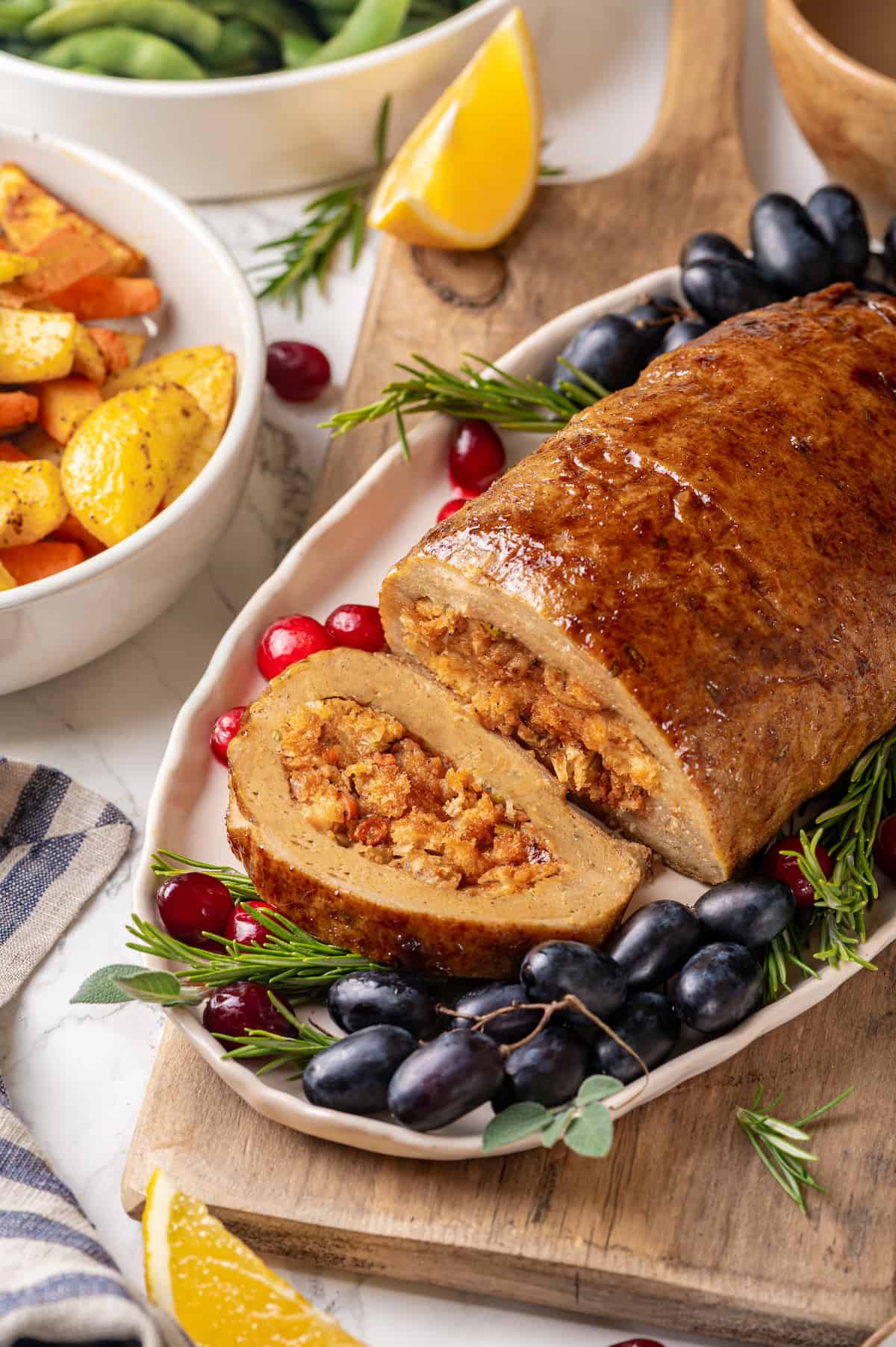 Vegan turkey on platter with one slice cut to show stuffing inside