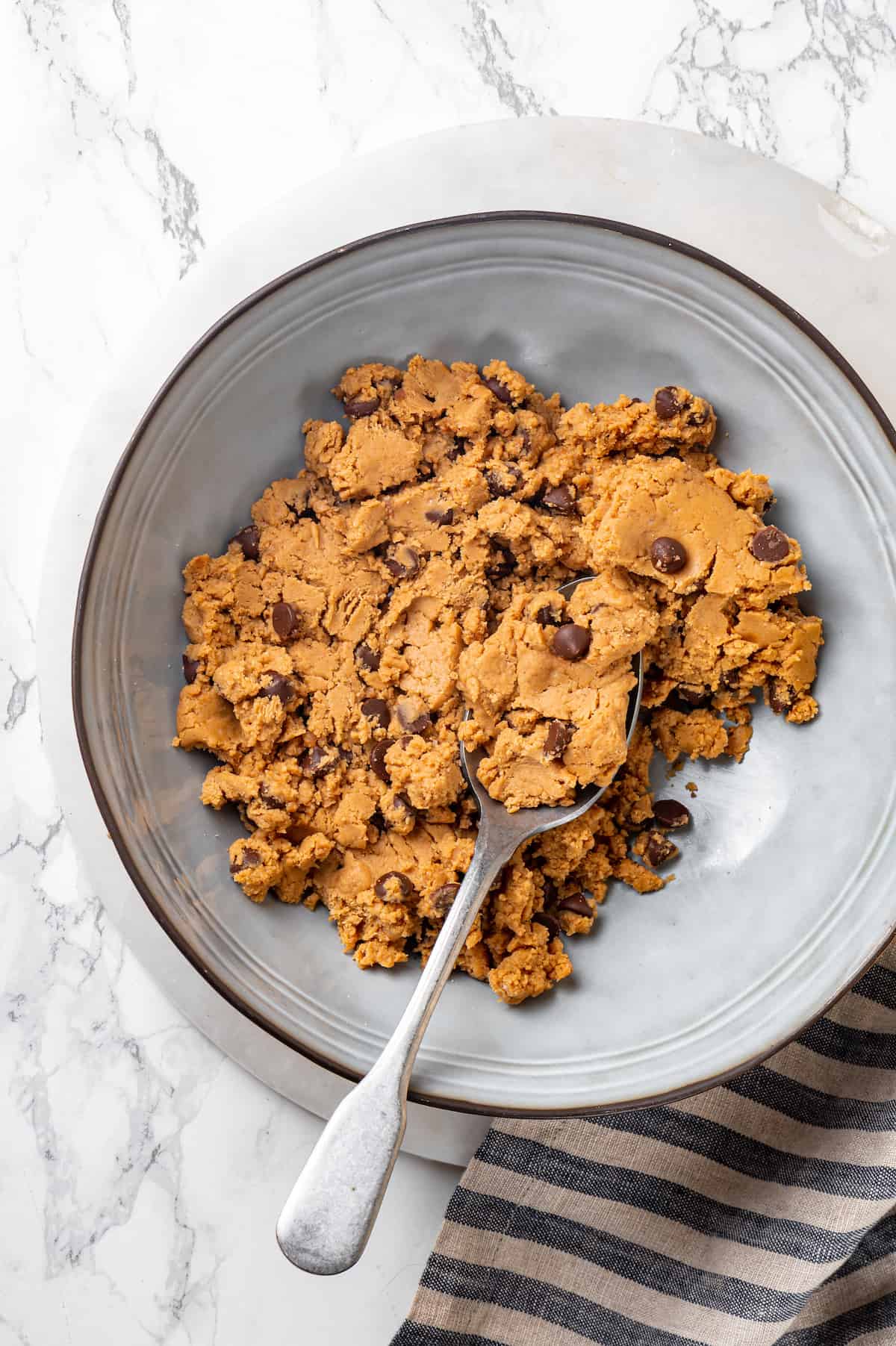 Overhead view of protein cookie dough in mixing bowl with spoon