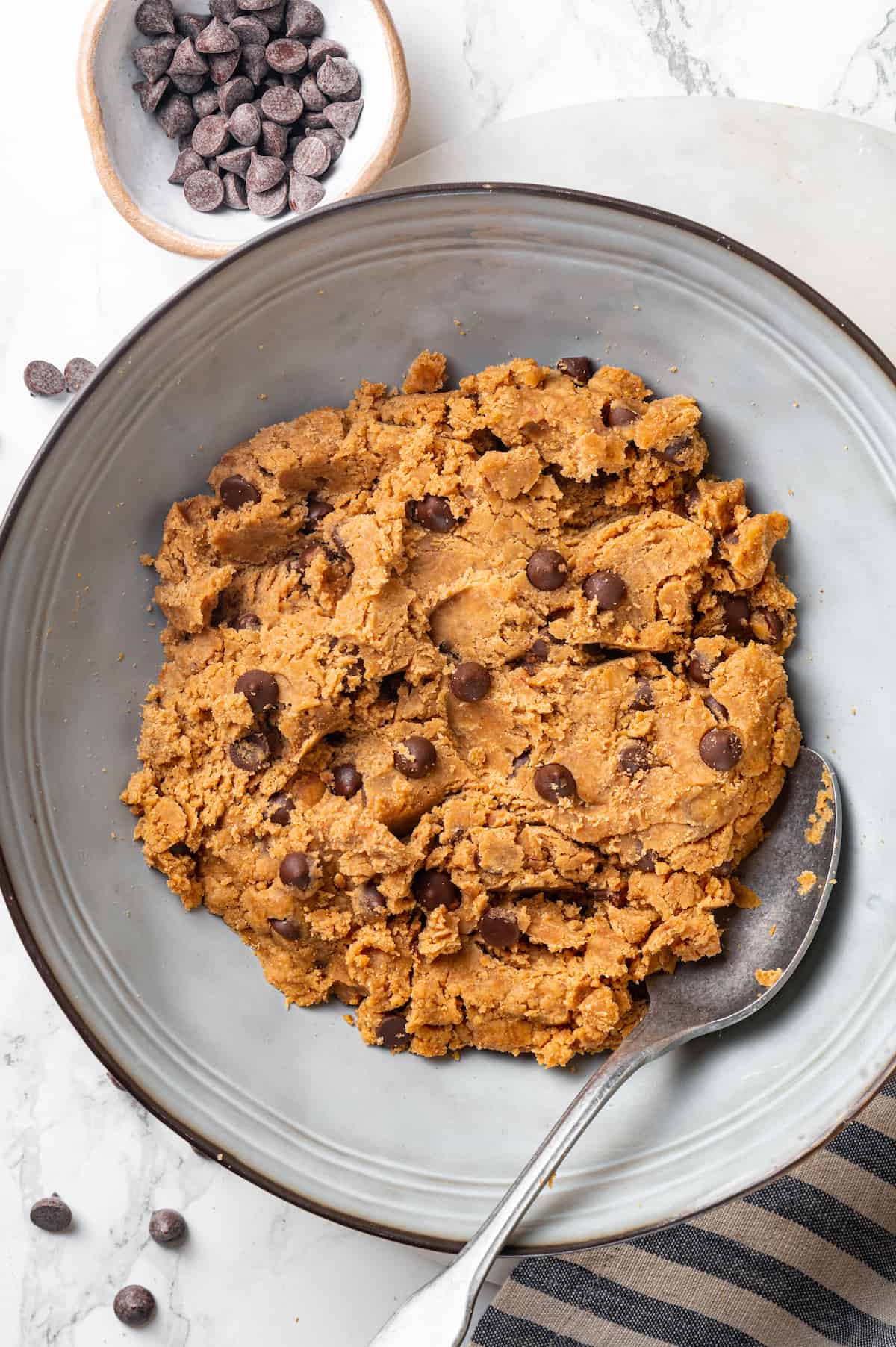 Overhead view of protein cookie dough in bowl with spoon