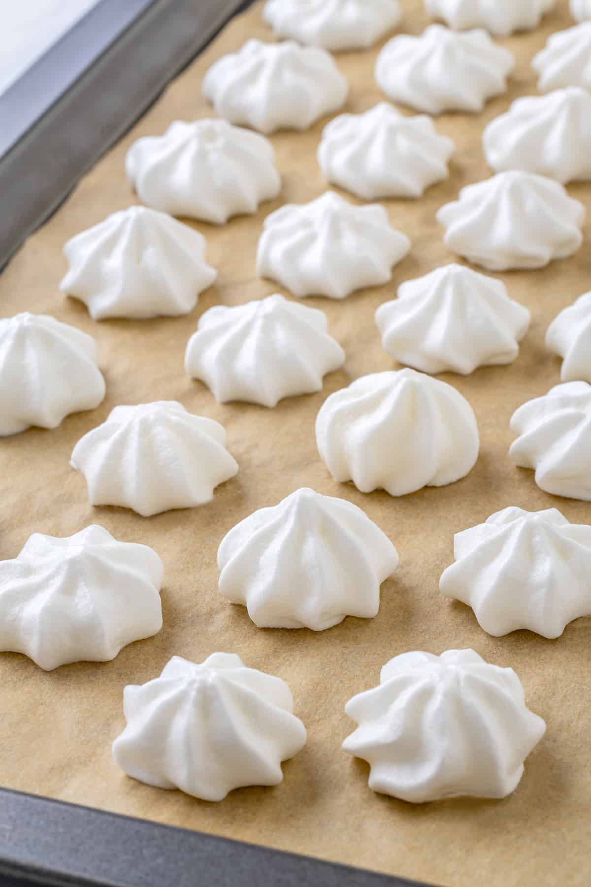 Vegan meringues on parchment lined baking sheet