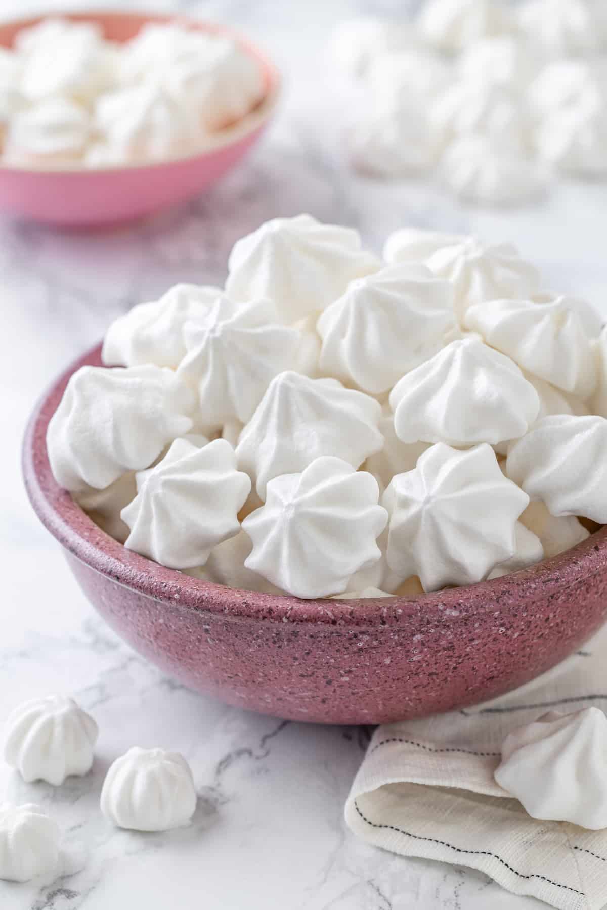 Vegan aquafaba meringues in pink bowls
