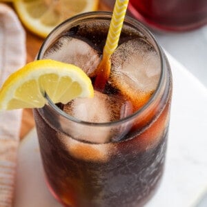 Top down view of Southern sweet tea in glass with ice and straw, with lemon wedge on rim