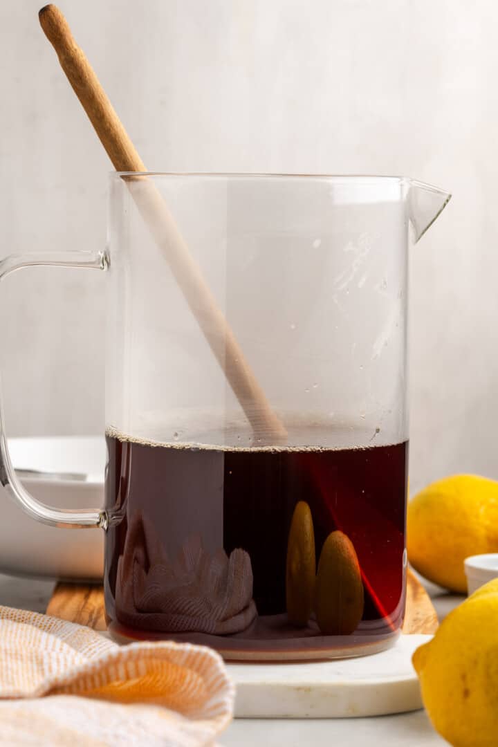 Stirring sugar into Southern sweet tea concentrate in pitcher