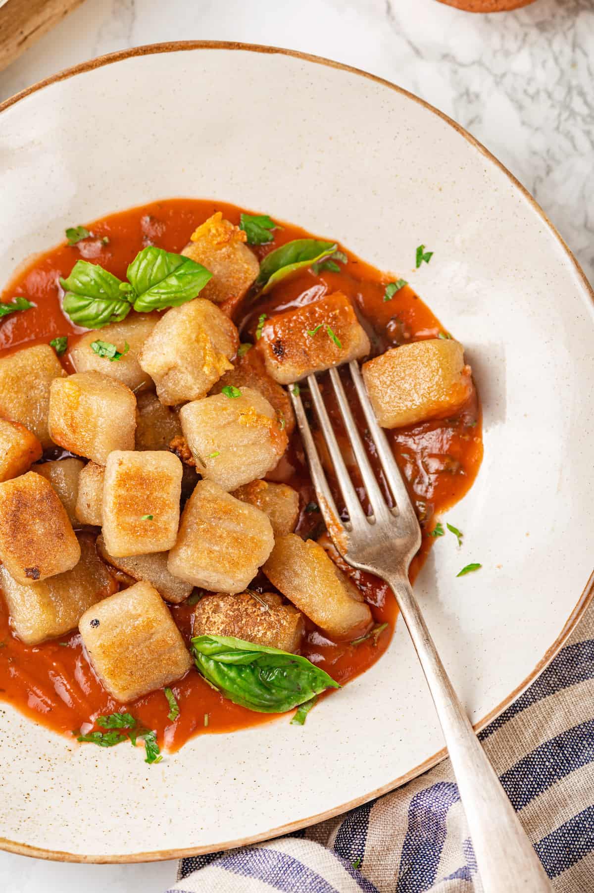 Overhead view of cauliflower gnocchi on plate with marinara and basil