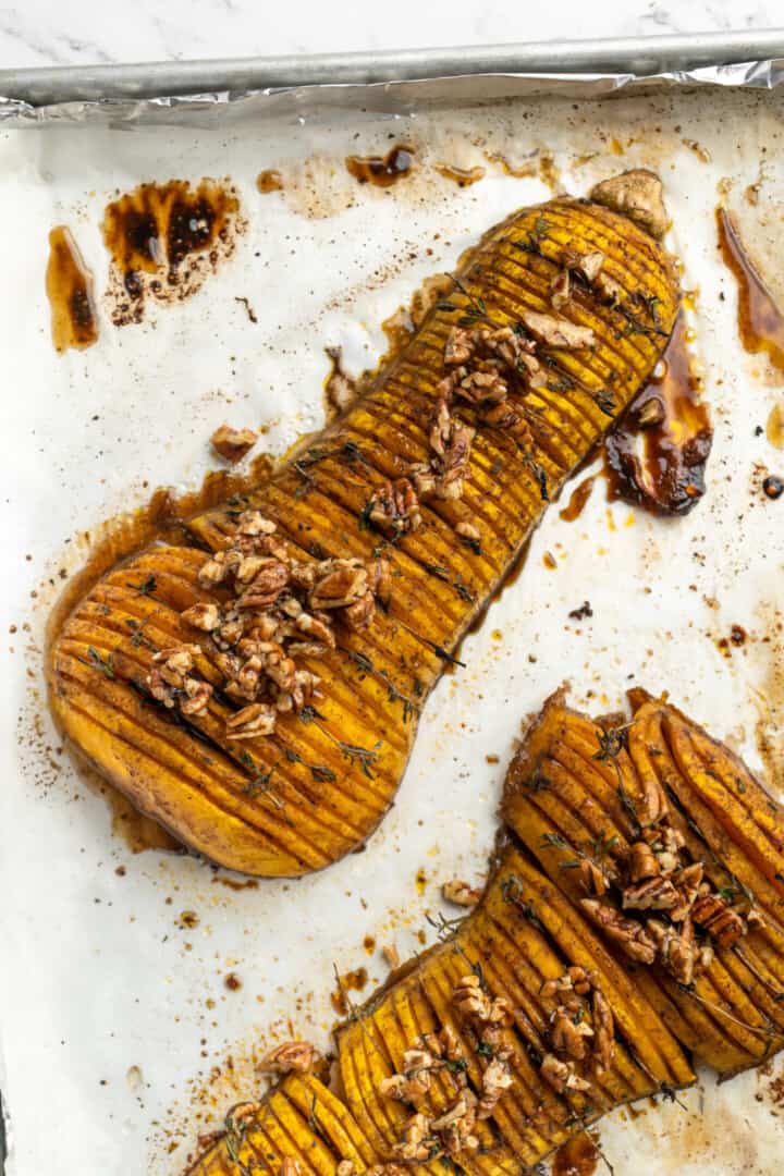 Hasselback butternut squash on parchment-lined baking sheet