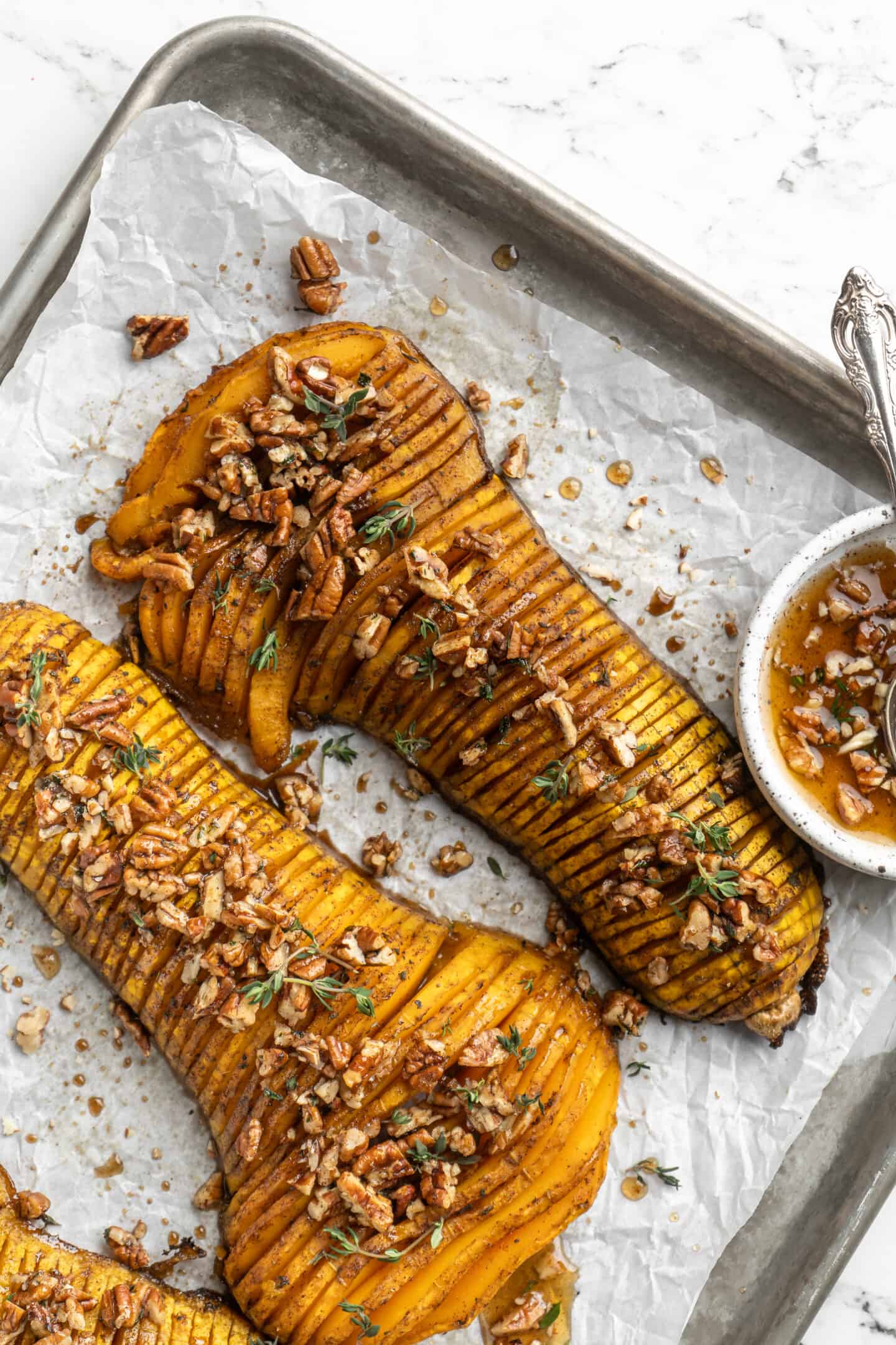 Overhead view of hasselback butternut squash on parchment-lined sheet pan