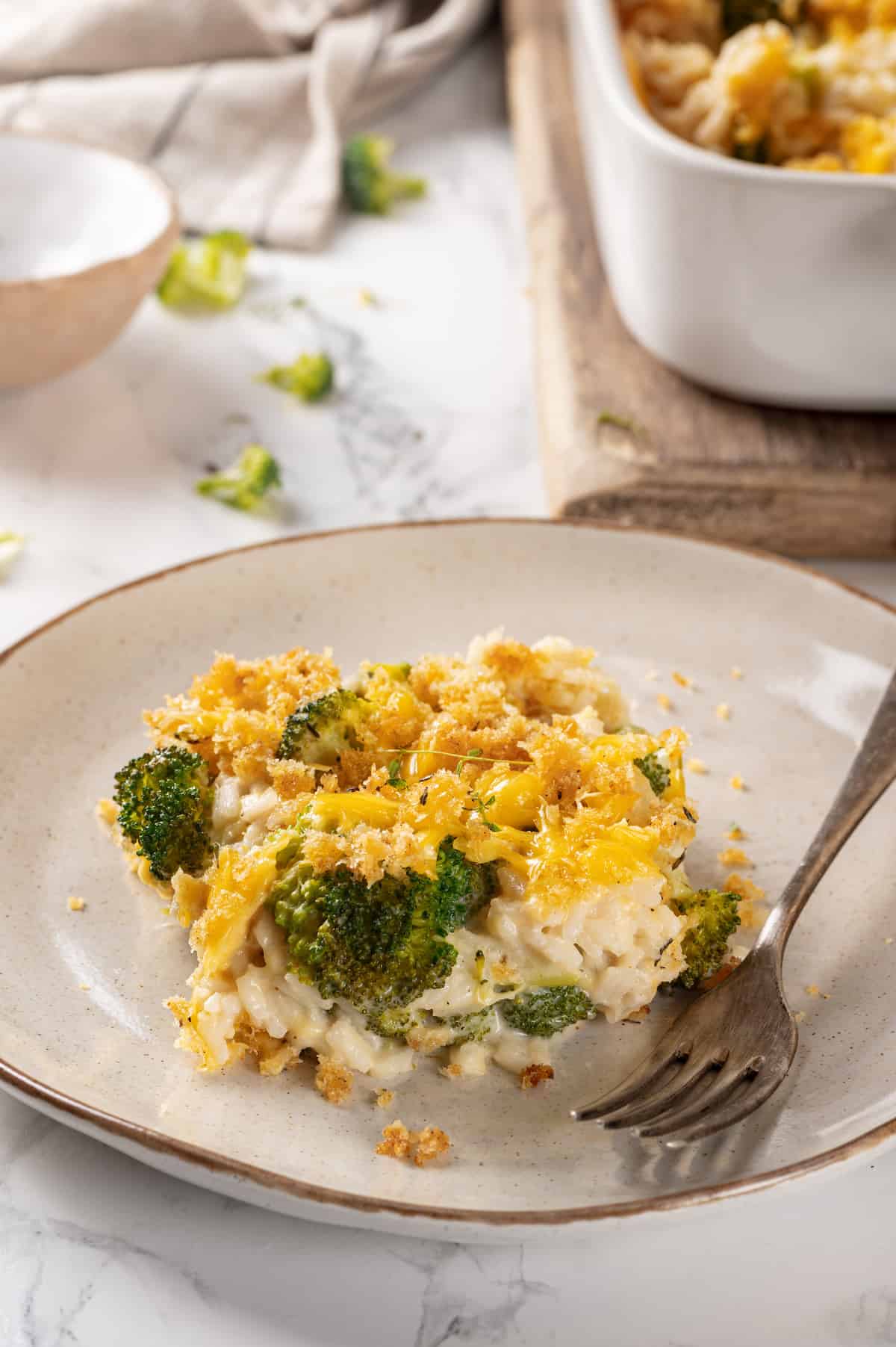 Plate with broccoli cheese rice casserole and fork