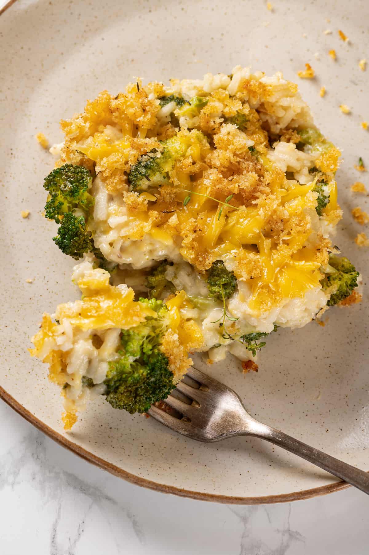 Plate with serving of broccoli cheese rice casserole and fork