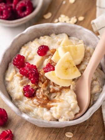 Baby oatmeal in bowl with banana, peanut butter, and berries