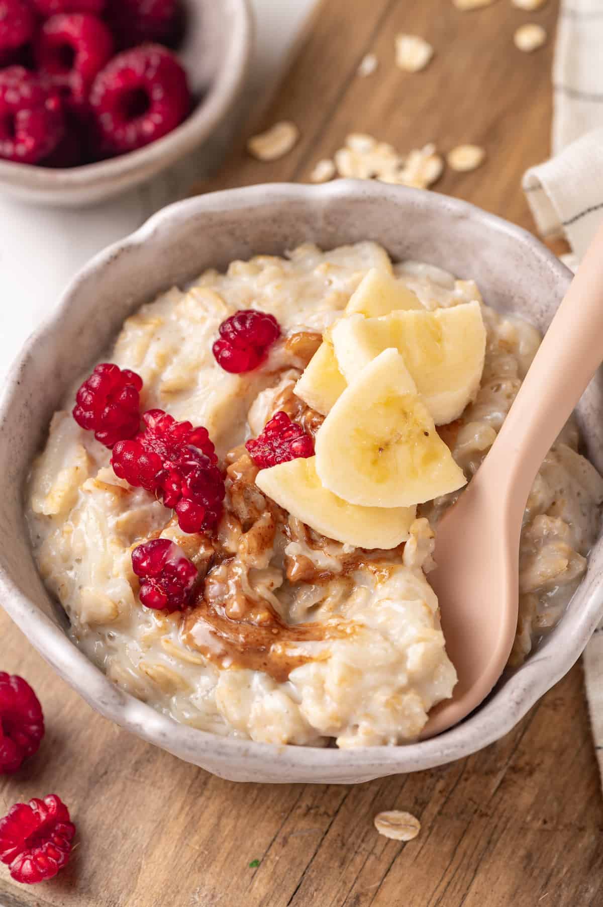Baby oatmeal in bowl with banana, peanut butter, and berries