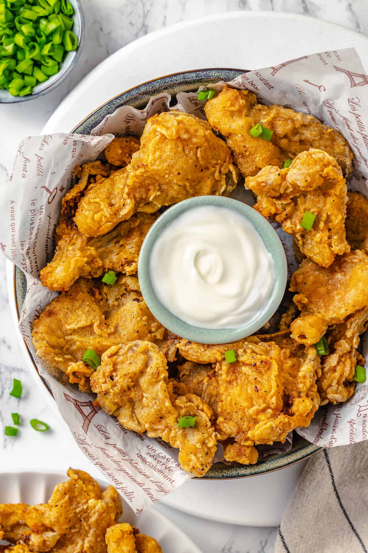 Overhead view of vegan fried chicken in bowl with creamy dipping sauce
