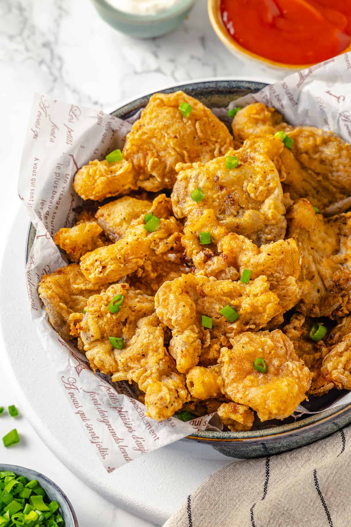 Bowl of vegan fried chicken garnished with sliced green onions