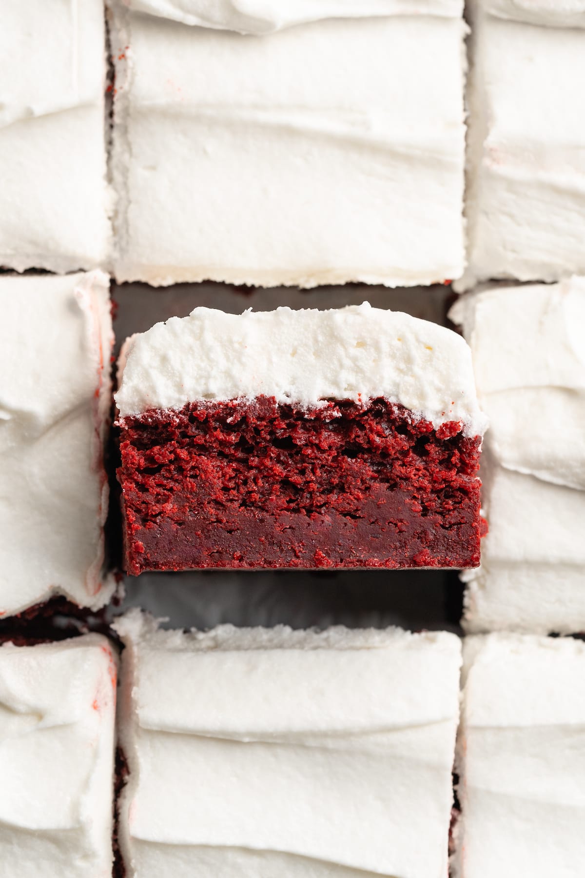 Red velvet brownies with one tipped sideways to show moist crumb