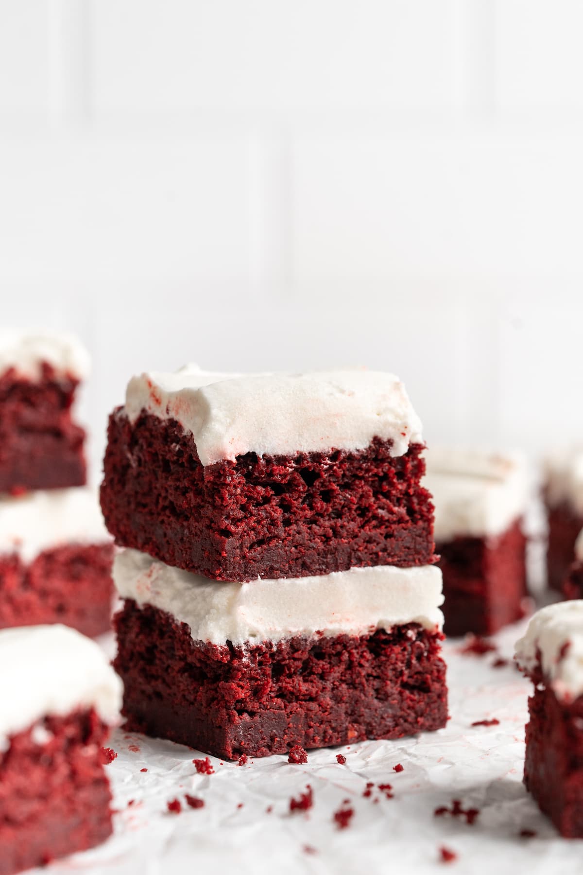 Two stacked red velvet brownies on parchment paper