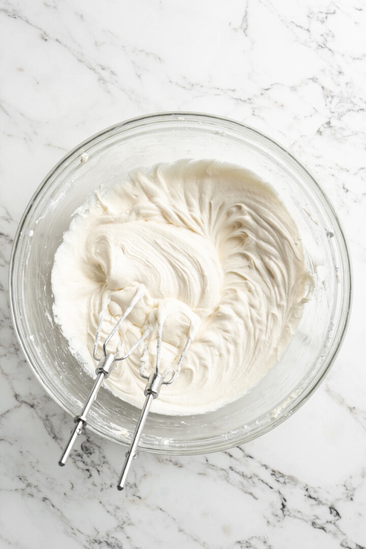 Overhead view of cream cheese frosting in mixing bowl with beaters