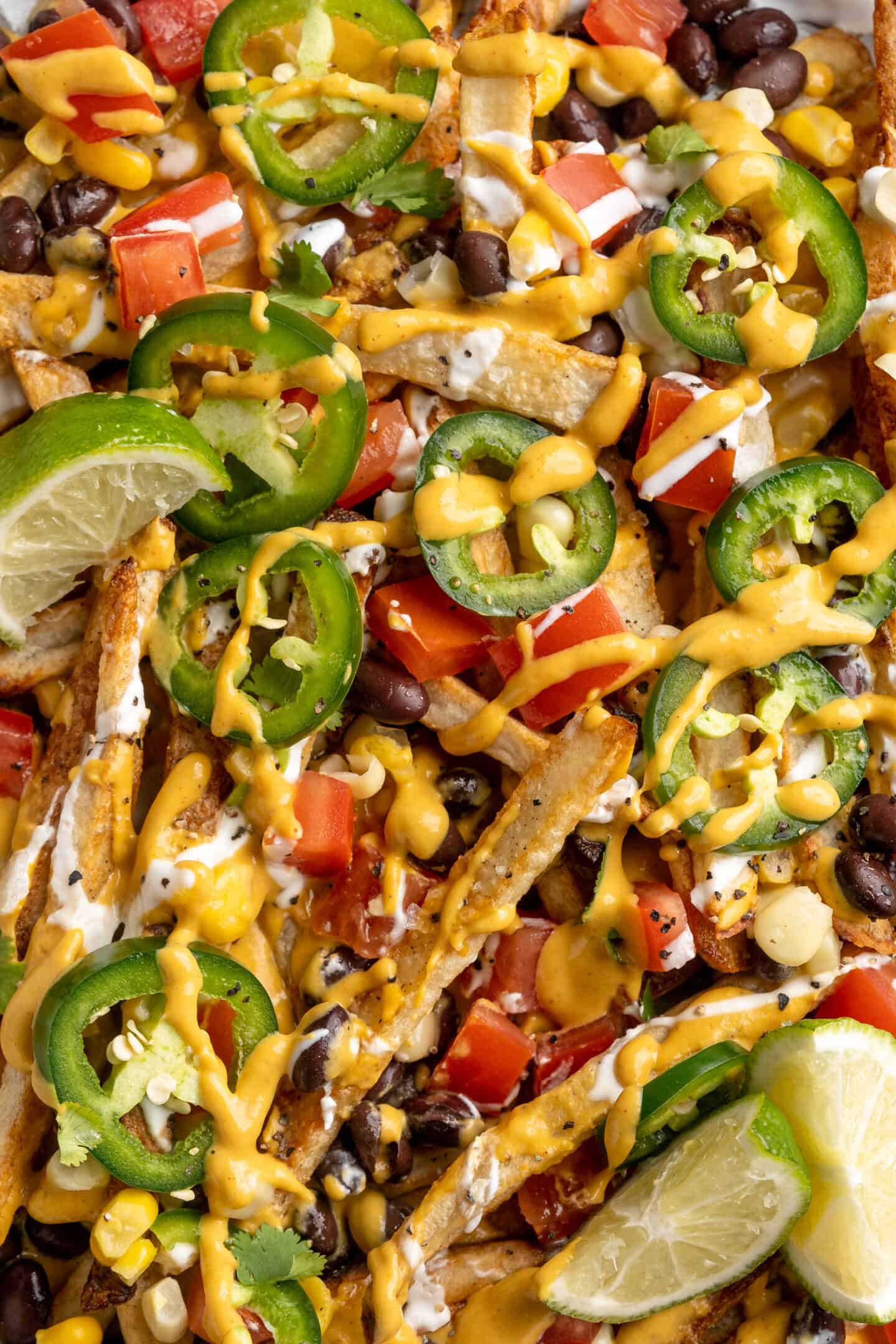 Overhead view of loaded nacho fries topped with vegan queso