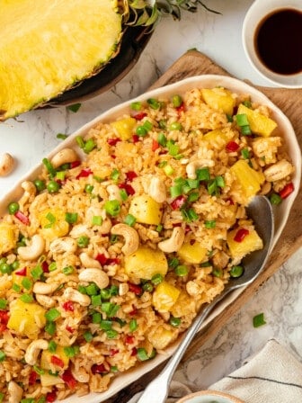 Overhead view of pineapple fried rice on platter with serving spoon