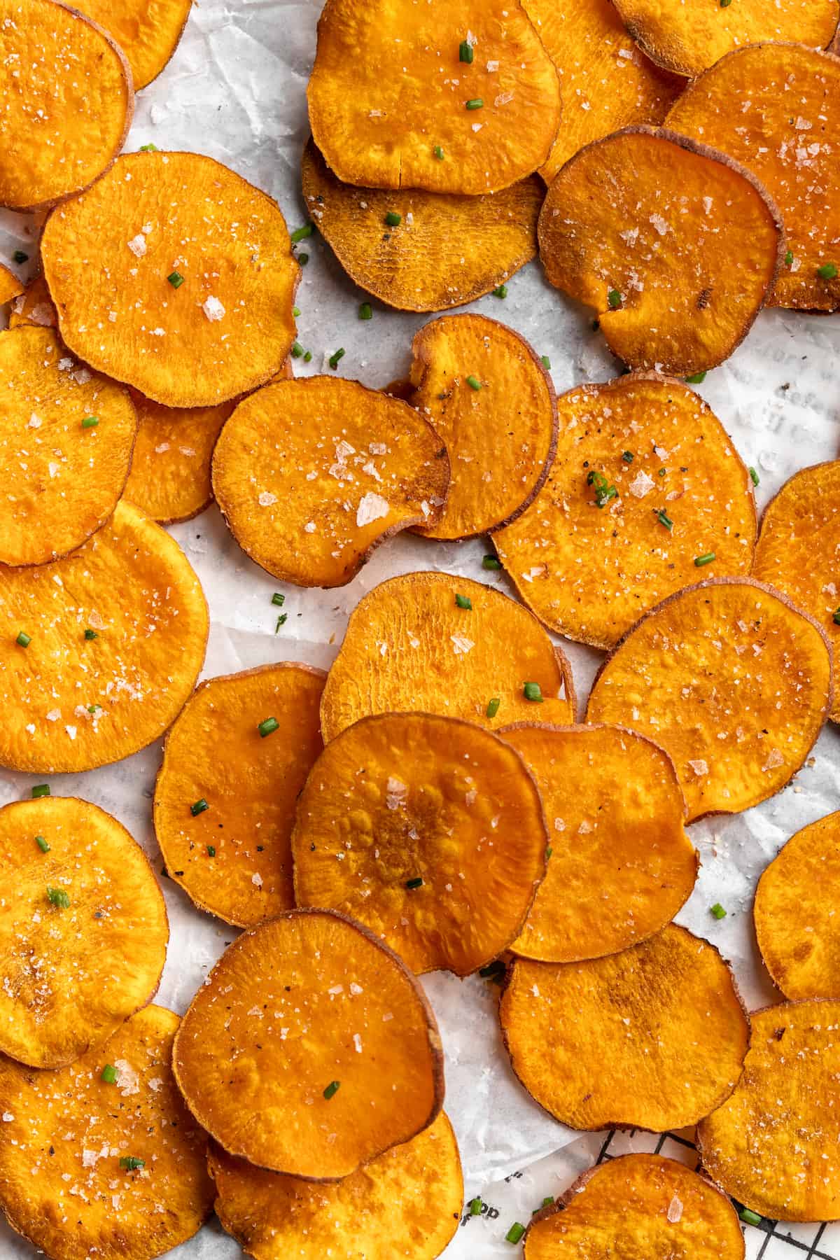 Homemade sweet potato chips topped with chives and flaky sea salt
