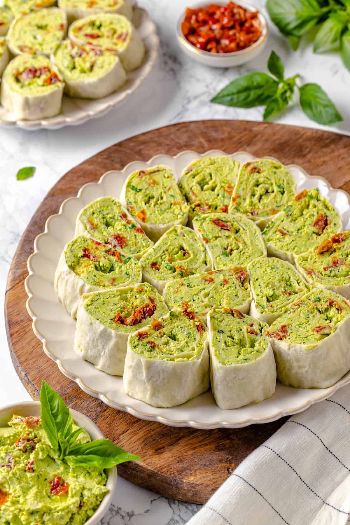 Plate of pesto pinwheel sandwiches with sun-dried tomatoes