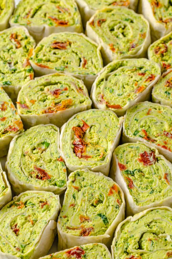 Overhead view of pesto roll-ups tightly packed together on platter