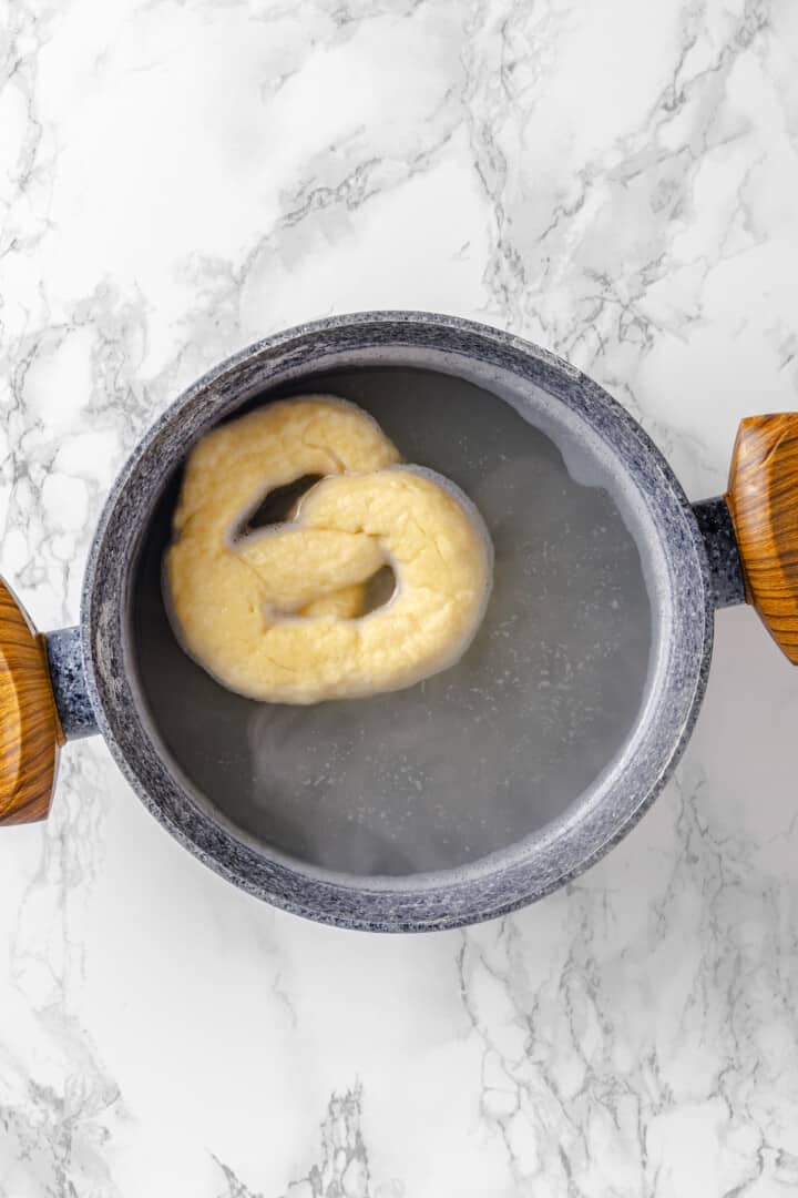 Overhead view of pretzel in boiling water