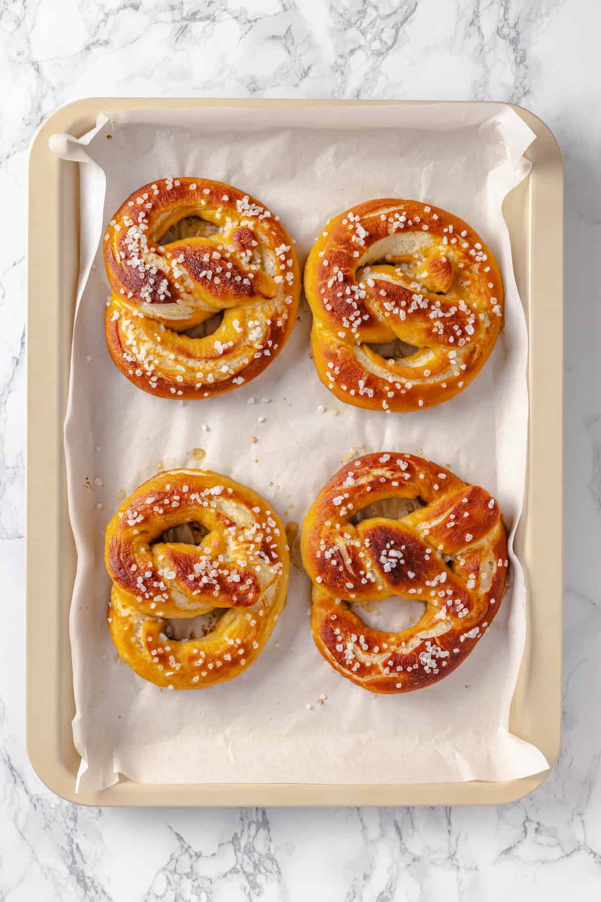 Overhead view of 4 vegan pretzels on sheet pan