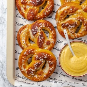 Overhead view of vegan soft pretzels on tray with beer cheese in bowl