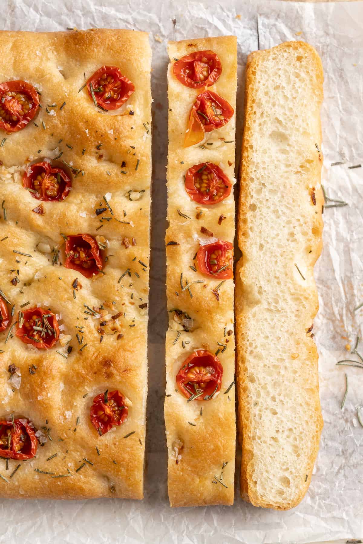 Slices of gluten-free focaccia topped with tomatoes and rosemary