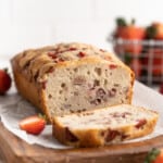 Loaf of strawberry banana bread with one slice cut