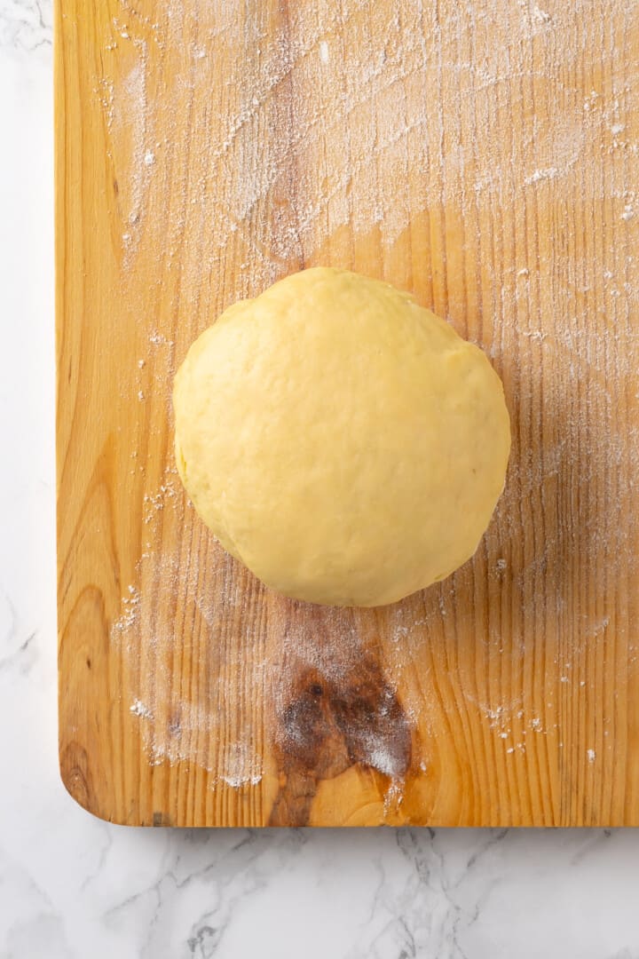Ball of pasta dough on floured board