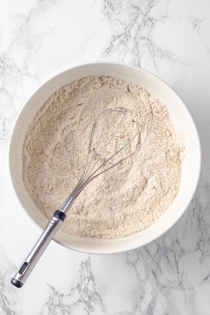 Overhead view of dry ingredients in mixing bowl with whisk