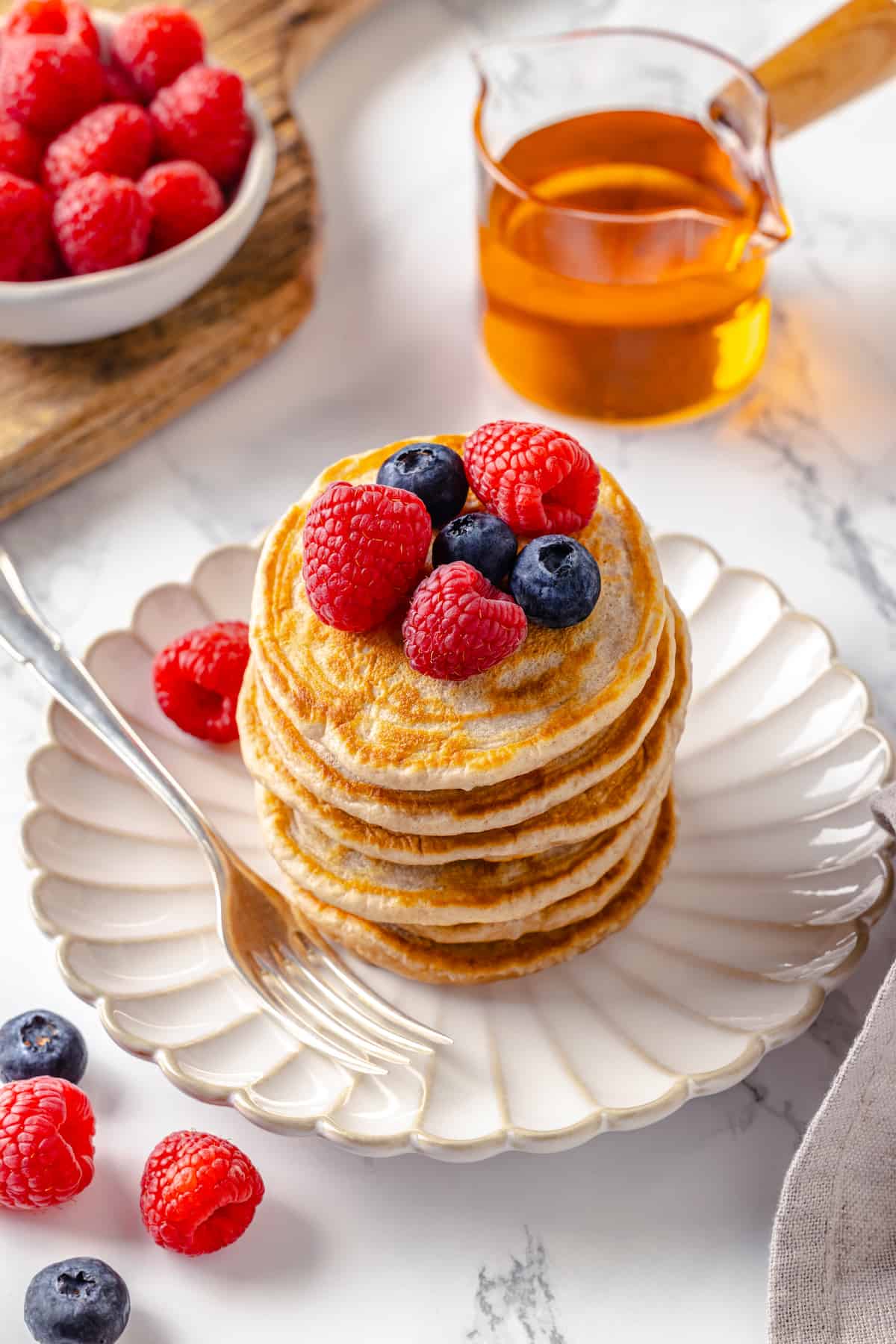 Stack of fluffy vegan silver dollar pancakes with fresh berries