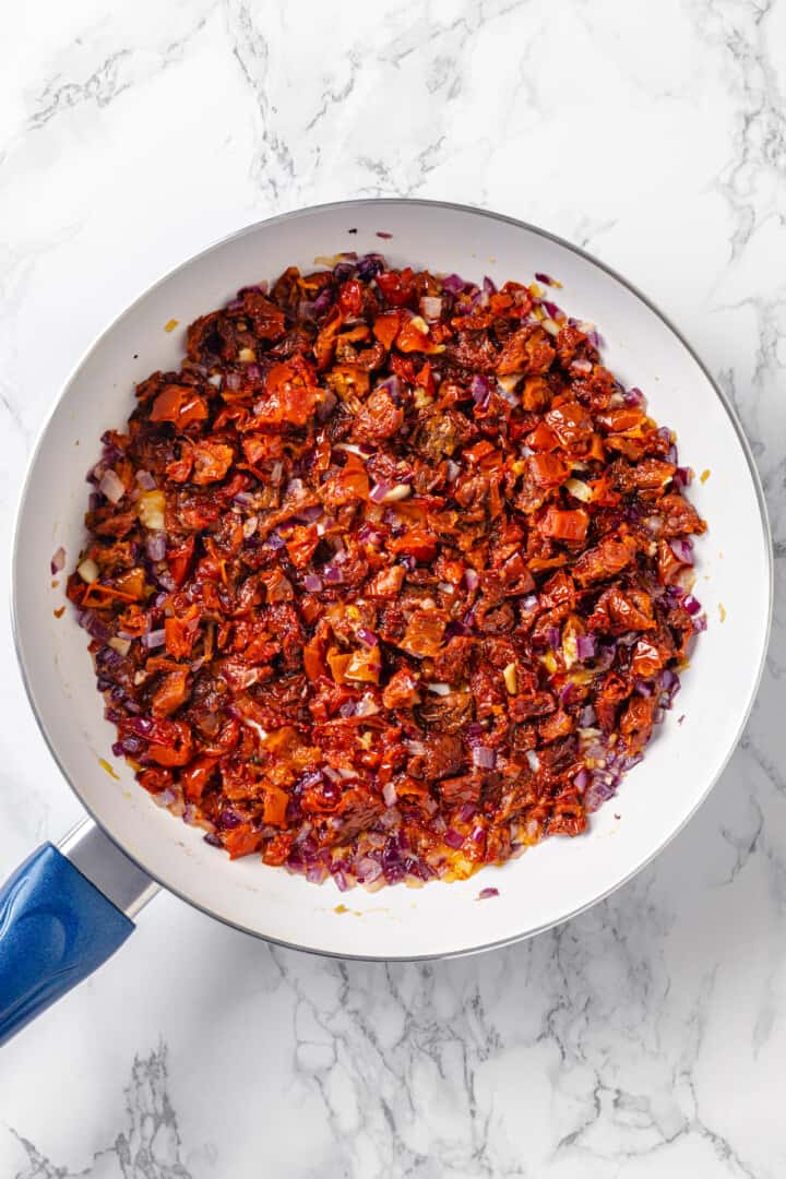 Sun-dried tomatoes in skillet with onions