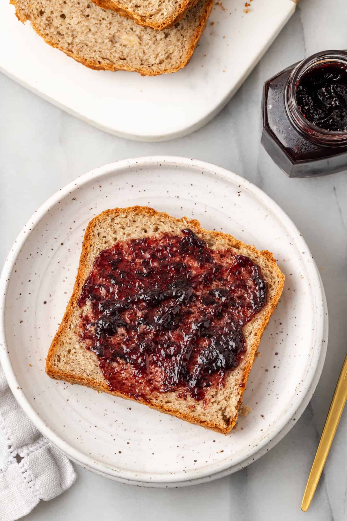 Overhead view of gluten-free sandwich bread spread with jam