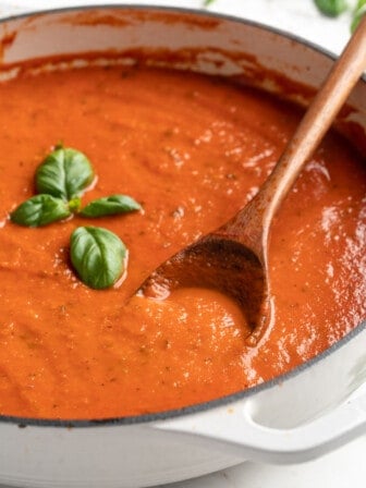 Pan of homemade tomato sauce garnished with basil