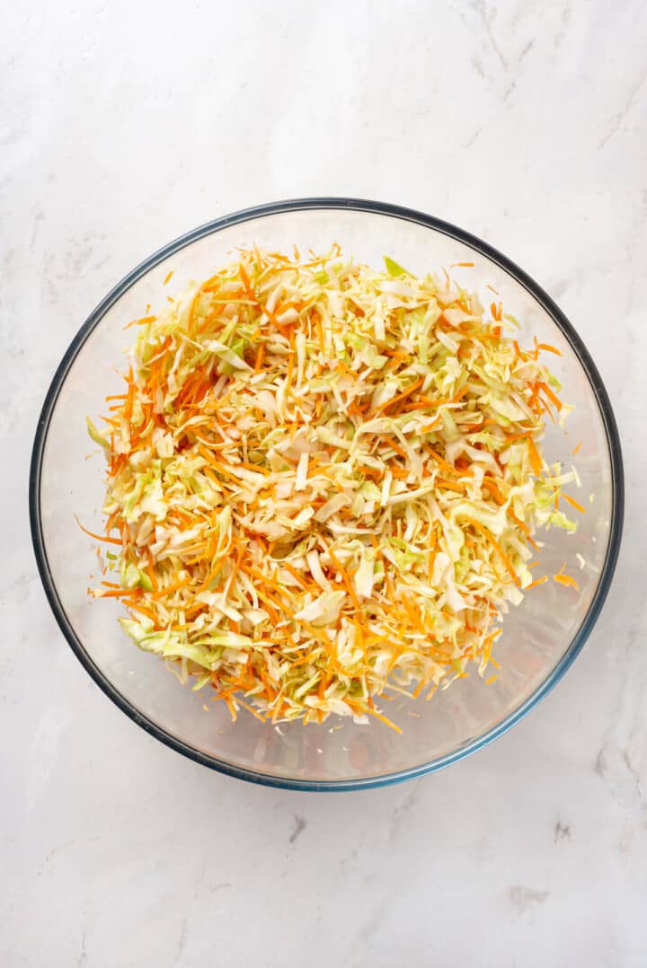 Overhead view of shredded cabbage and carrot in bowl