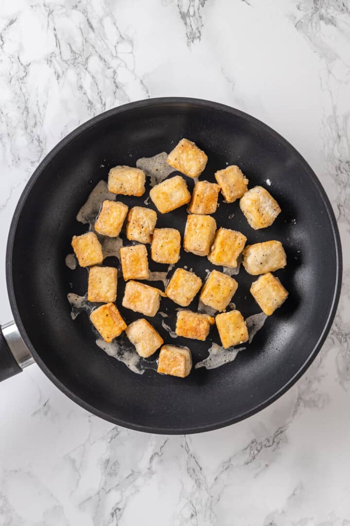 Tofu cubes cooking in pan