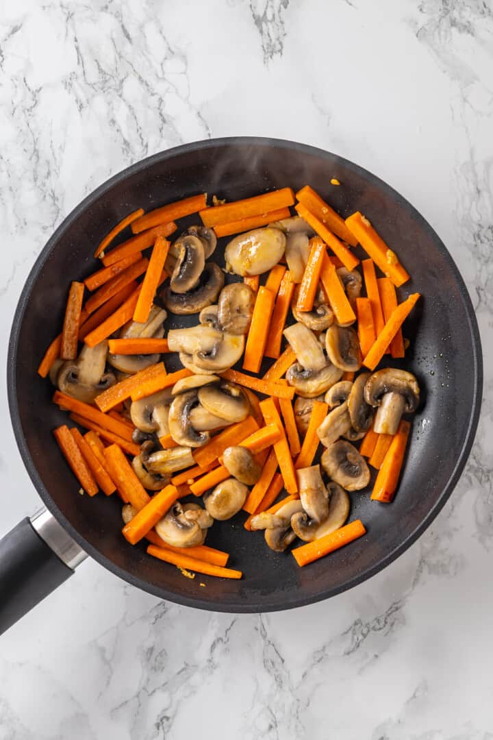 Carrots and mushrooms in pan