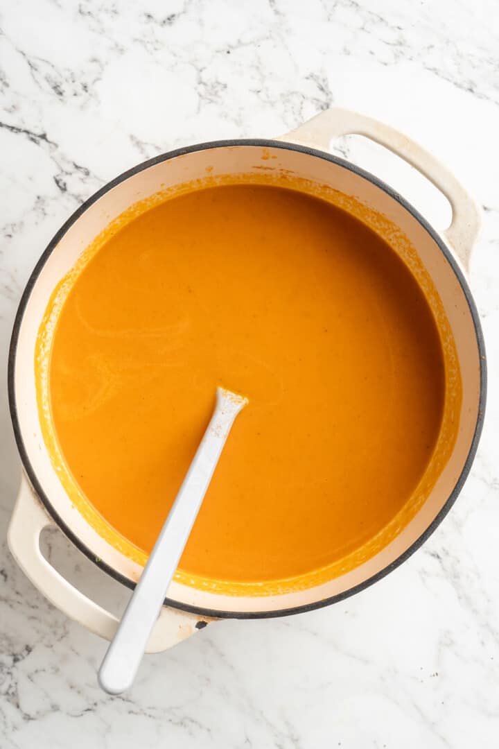 Overhead view of creamy tomato soup in pot