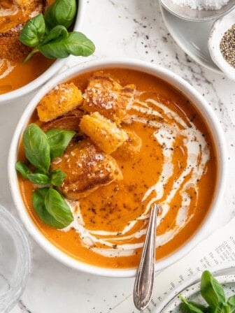 Overhead view of creamy tomato soup with cheesy croutons in bowl