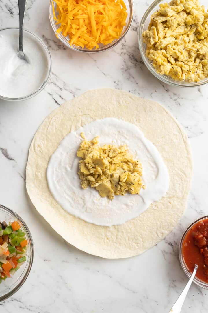 Overhead view of tortilla topped with vegan yogurt and vegan scramble