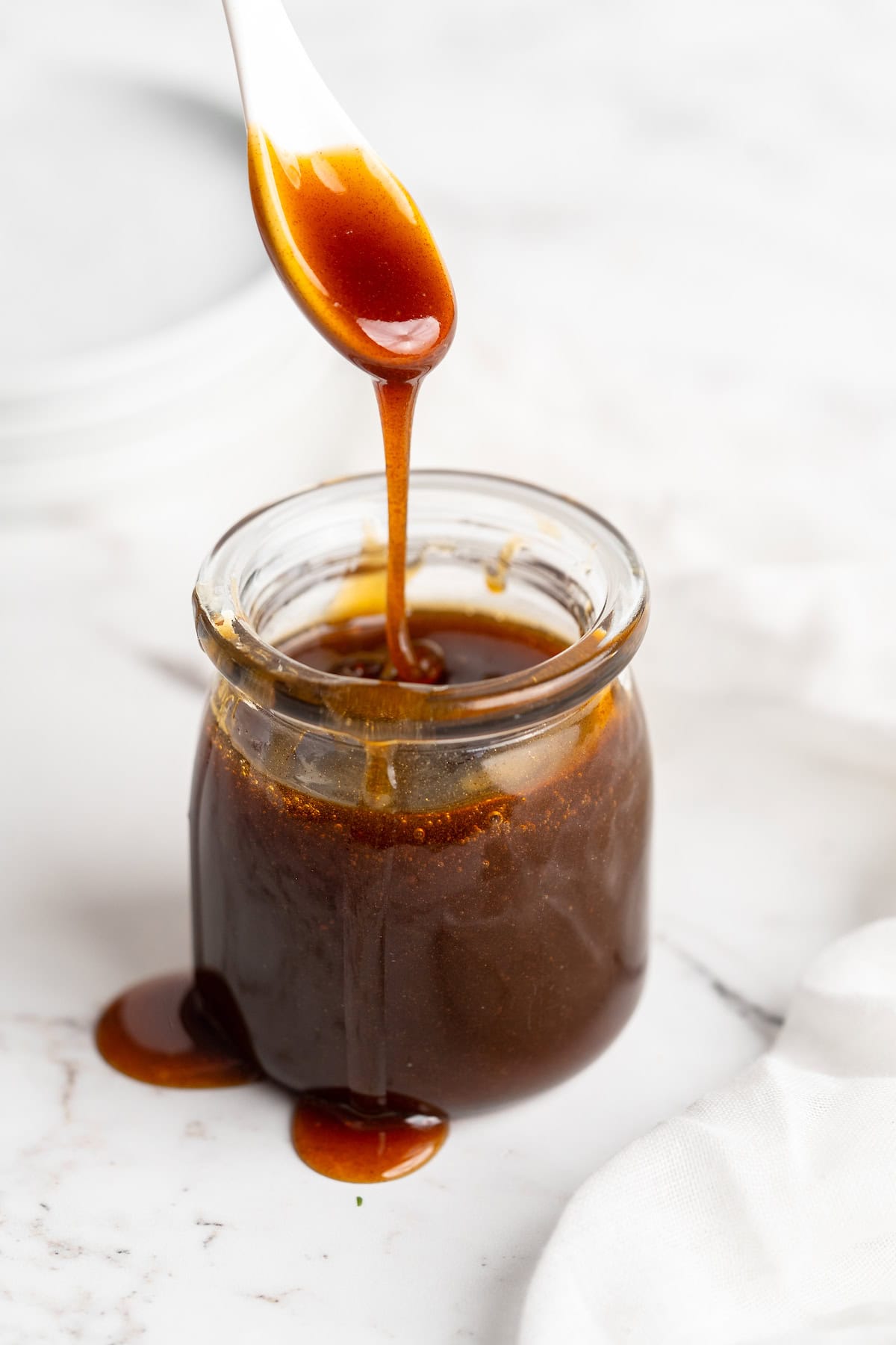 Spoon drizzling date syrup into jar