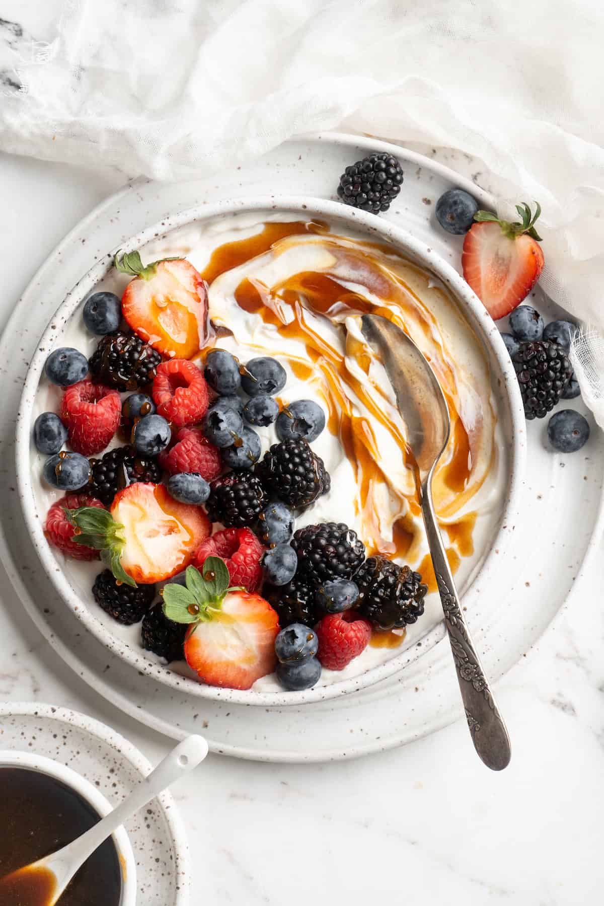 Date syrup swirled into bowl of yogurt with fresh berries