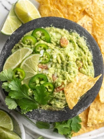 Overhead view of guacamole in bowl surrounded by tortilla chips