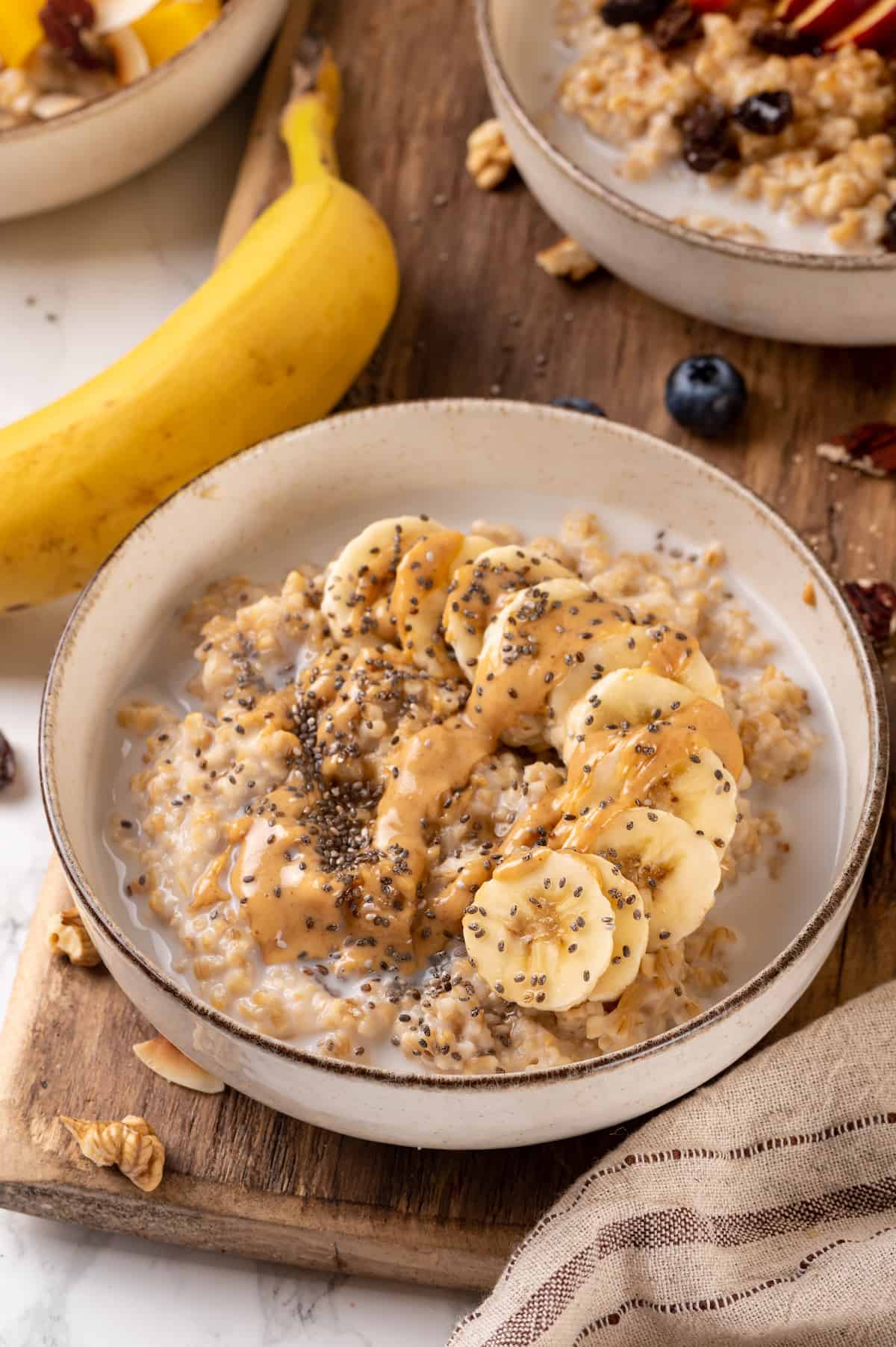 Bowl of Instant Pot steel-cut oats topped with banana, peanut butter, and chia seeds