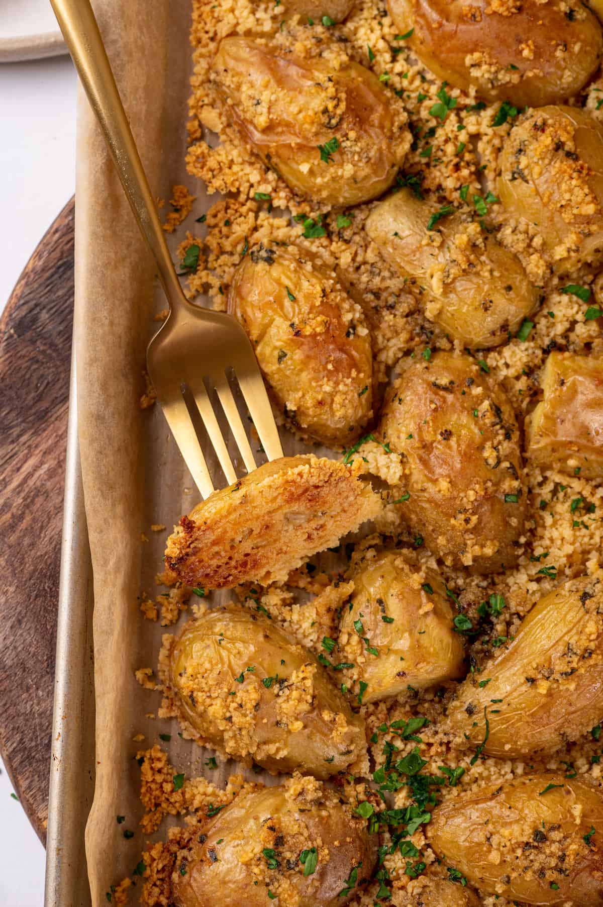 Parmesan-crusted potatoes on baking sheet with fork