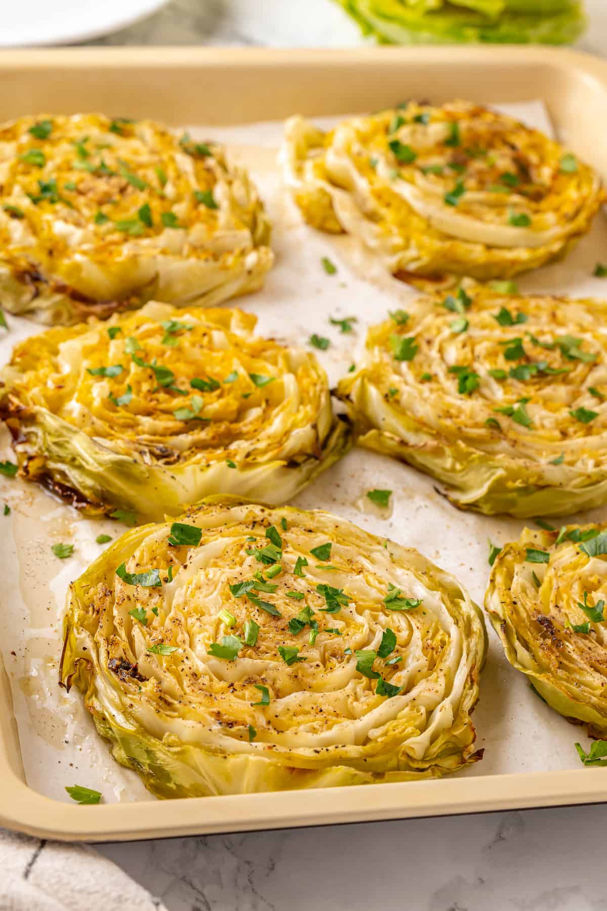 Roasted cabbage steaks on sheet pan with parsley