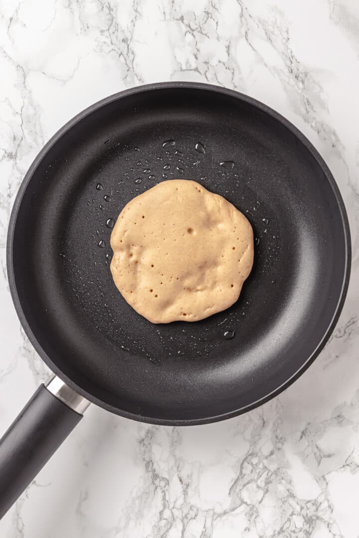 Overhead view of pancake in skillet before flipping