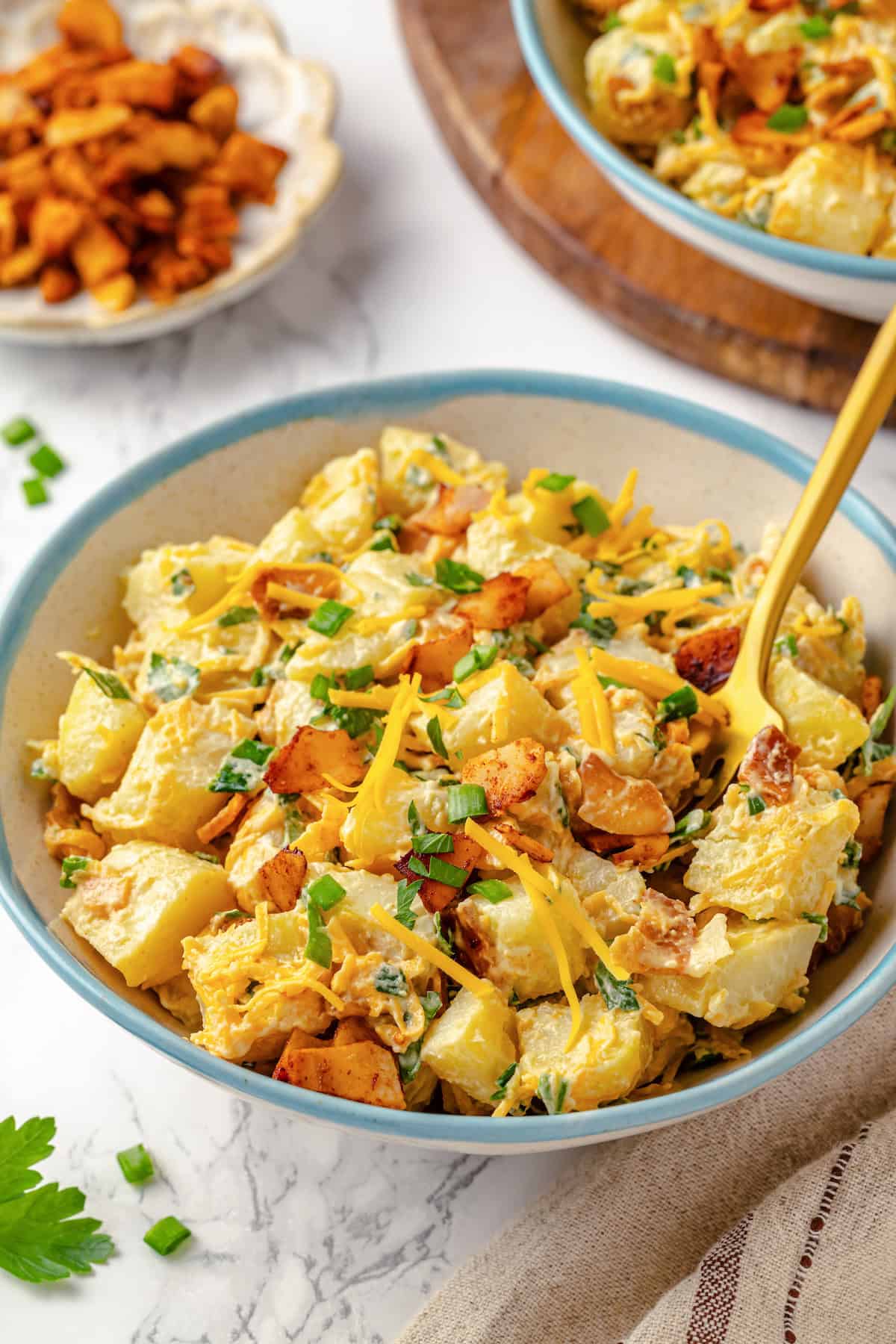 Creamy loaded potato salad in bowl with fork