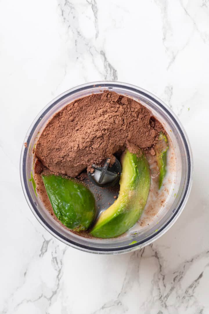 Overhead view of ingredients for avocado chocolate mousse in food processor